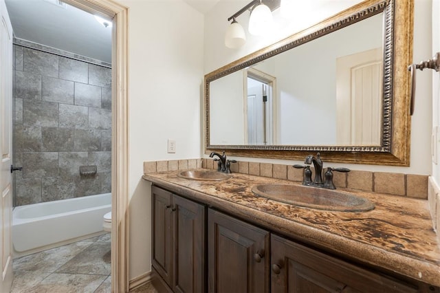 full bathroom featuring vanity, tiled shower / bath, and toilet