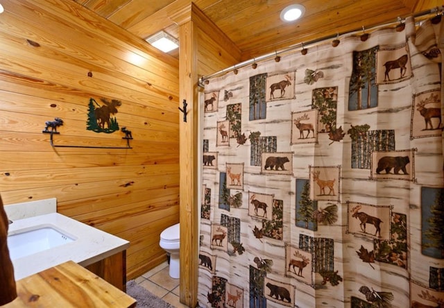 bathroom featuring wooden walls, toilet, wood ceiling, tile patterned flooring, and vanity