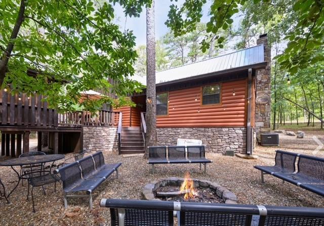 view of yard featuring an outdoor fire pit, stairs, and central AC