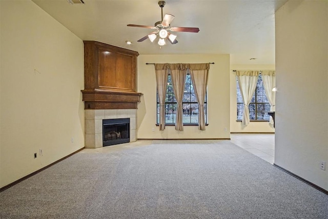 unfurnished living room with ceiling fan, light colored carpet, and a fireplace