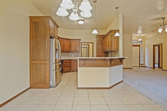 kitchen featuring hanging light fixtures, stainless steel fridge, light colored carpet, ceiling fan with notable chandelier, and decorative backsplash