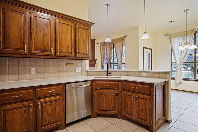 kitchen featuring decorative light fixtures, dishwasher, sink, and kitchen peninsula