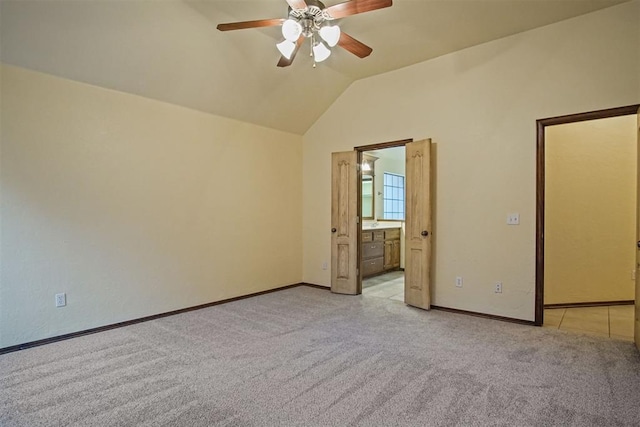 unfurnished bedroom with vaulted ceiling, connected bathroom, light carpet, and ceiling fan