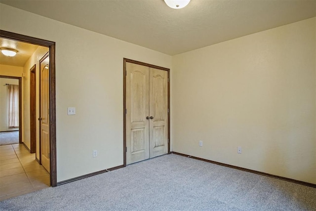 unfurnished bedroom featuring light colored carpet and a closet