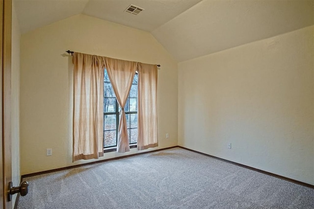 empty room with vaulted ceiling and carpet floors