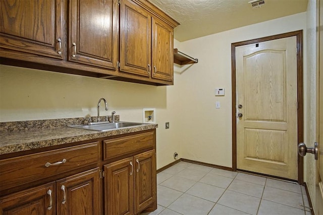 kitchen featuring sink, a textured ceiling, and light tile patterned floors