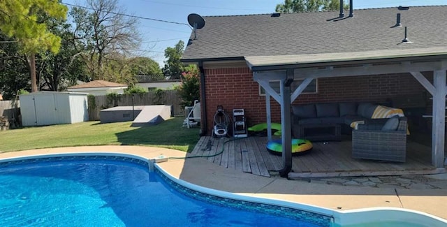 view of pool featuring a wooden deck, an outdoor living space, a shed, and a lawn