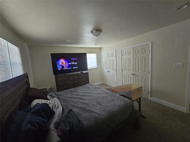 bedroom featuring two closets and carpet flooring