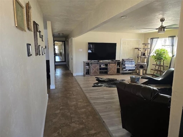 living room featuring ceiling fan, wood-type flooring, and a textured ceiling