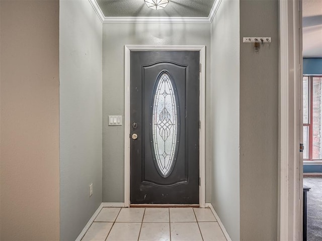 tiled foyer with crown molding and baseboards