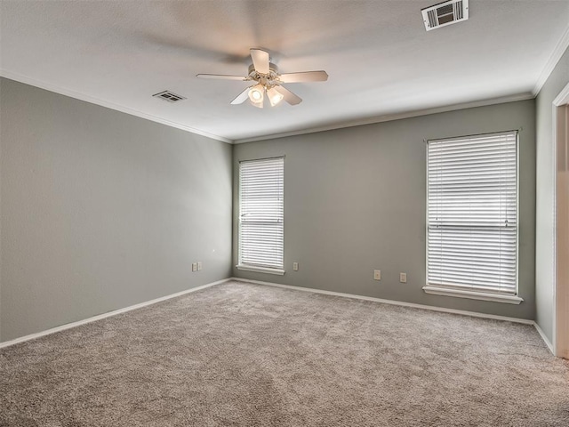 unfurnished room featuring carpet, visible vents, ceiling fan, and crown molding