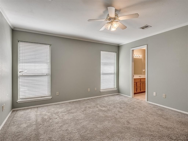 empty room featuring light colored carpet, a ceiling fan, baseboards, visible vents, and ornamental molding