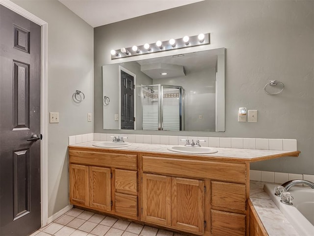 full bathroom featuring a stall shower, double vanity, a sink, and tile patterned floors