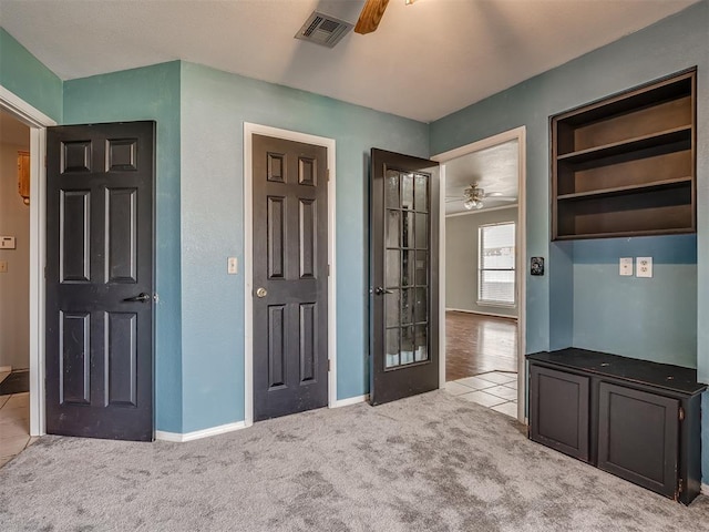 interior space with ceiling fan, carpet floors, visible vents, and baseboards