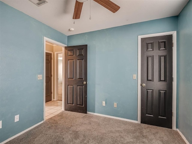 unfurnished bedroom with carpet flooring, ceiling fan, visible vents, and baseboards