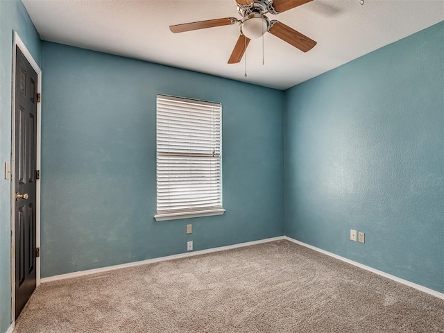 spare room featuring a ceiling fan, carpet flooring, a textured wall, and baseboards