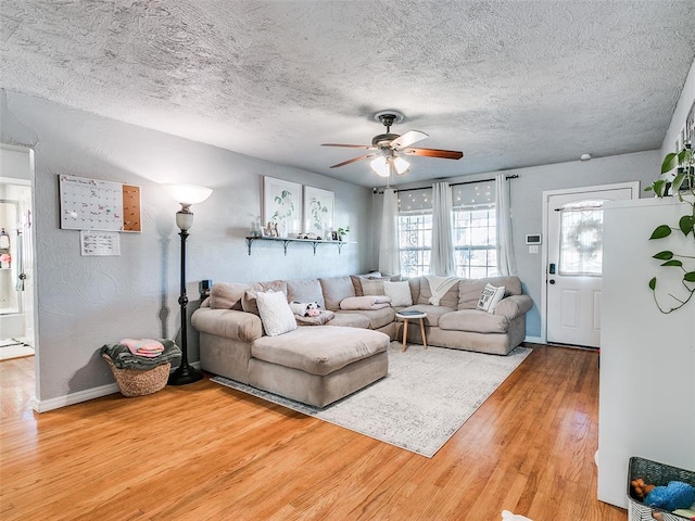 living room featuring ceiling fan, hardwood / wood-style floors, and a textured ceiling