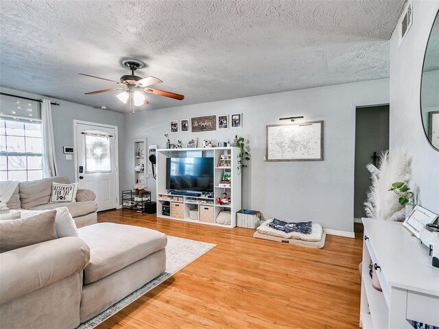 living room with hardwood / wood-style floors, a textured ceiling, and ceiling fan