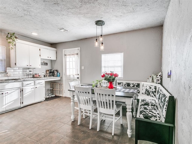 tiled dining room with a textured ceiling