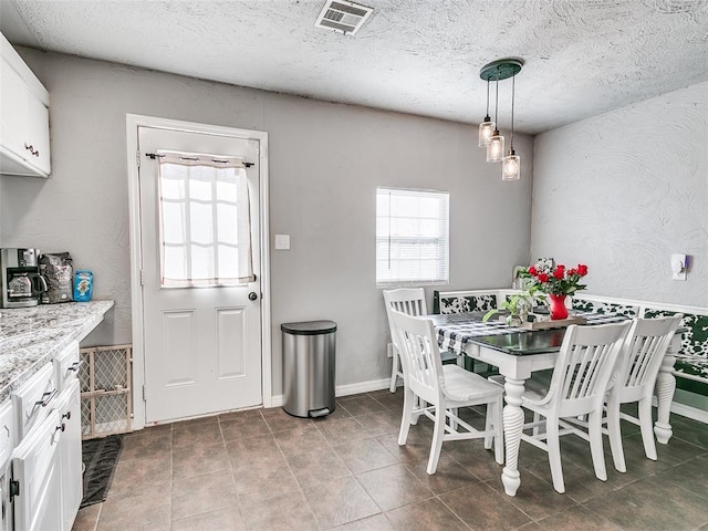 tiled dining area featuring a textured ceiling