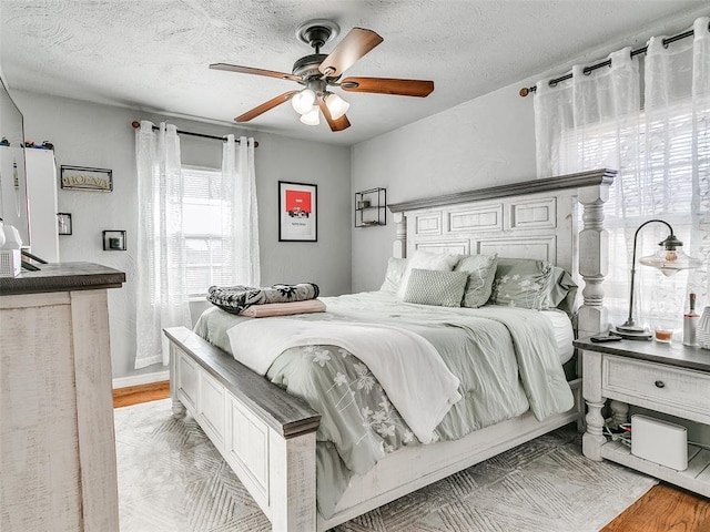 bedroom with ceiling fan and a textured ceiling