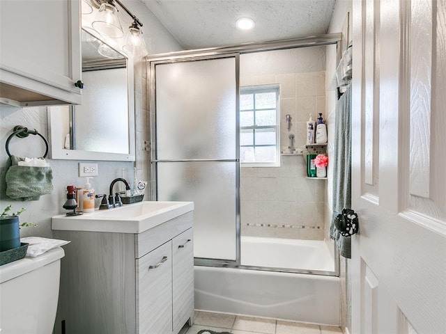 full bathroom featuring enclosed tub / shower combo, tile patterned flooring, vanity, a textured ceiling, and toilet