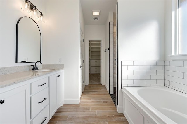 bathroom with a tub to relax in and vanity