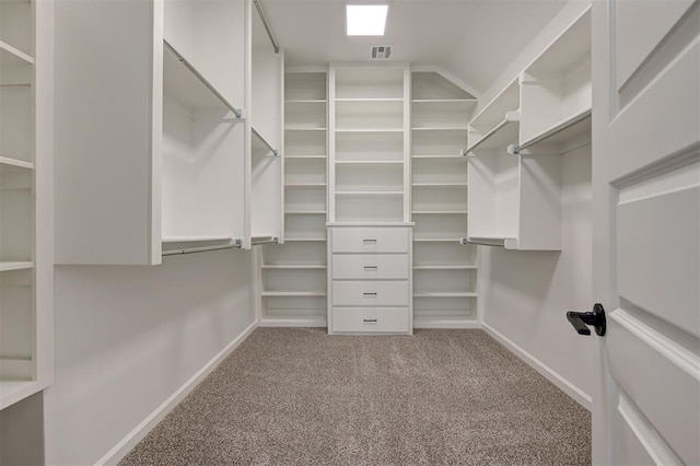 spacious closet featuring lofted ceiling and light colored carpet