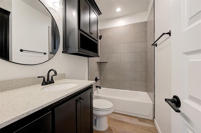 full bathroom with tiled shower / bath combo, vanity, and toilet