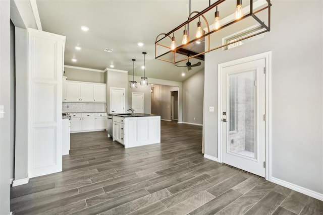 kitchen featuring pendant lighting, white cabinetry, a kitchen island with sink, dark hardwood / wood-style flooring, and decorative backsplash