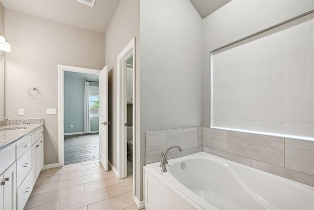 bathroom with vanity, toilet, tile patterned flooring, and a bathtub