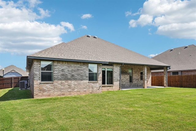 rear view of property featuring cooling unit and a yard