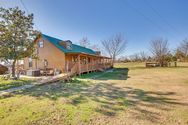 exterior space featuring a deck, central AC unit, a patio area, and a lawn