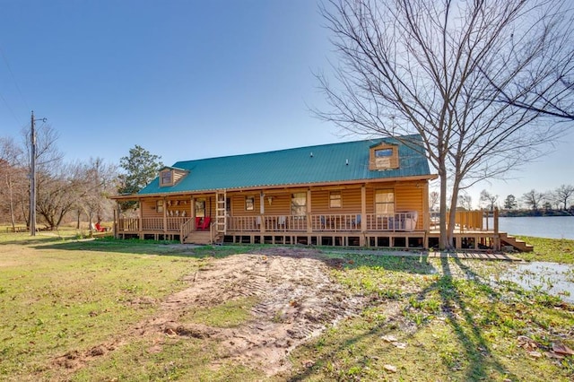 log cabin with a front yard and a water view