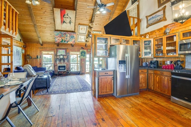 kitchen with appliances with stainless steel finishes, wood-type flooring, ceiling fan, wooden ceiling, and beam ceiling