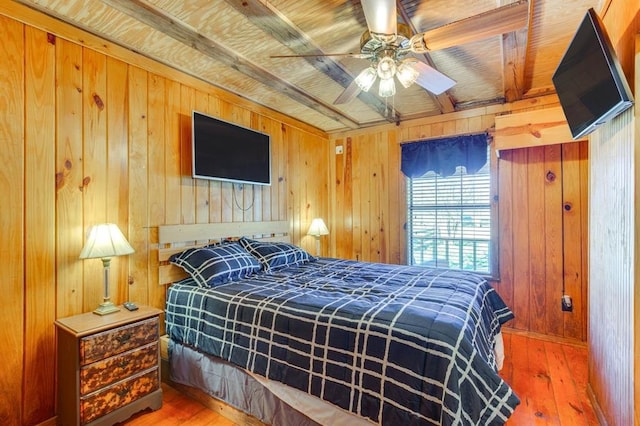 bedroom featuring wood-type flooring, ceiling fan, and wood walls