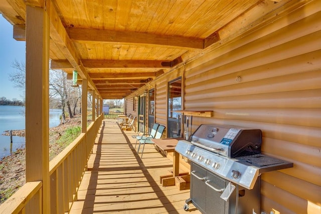 deck with a water view and area for grilling