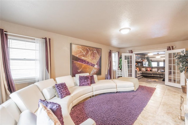 living room featuring french doors, light tile patterned floors, and a wealth of natural light