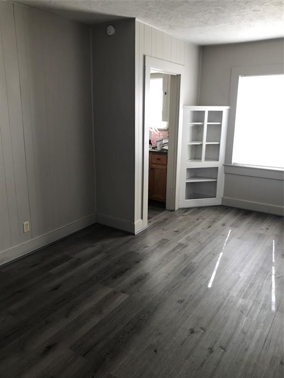 spare room featuring dark hardwood / wood-style floors and a textured ceiling