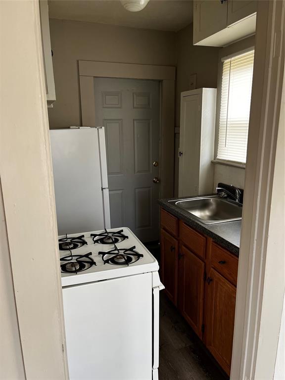 kitchen featuring dark hardwood / wood-style flooring, sink, and white appliances