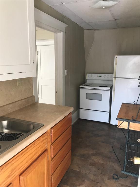 kitchen with a drop ceiling and white appliances