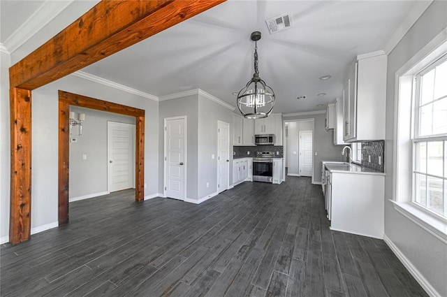 kitchen featuring white cabinetry, appliances with stainless steel finishes, backsplash, and crown molding