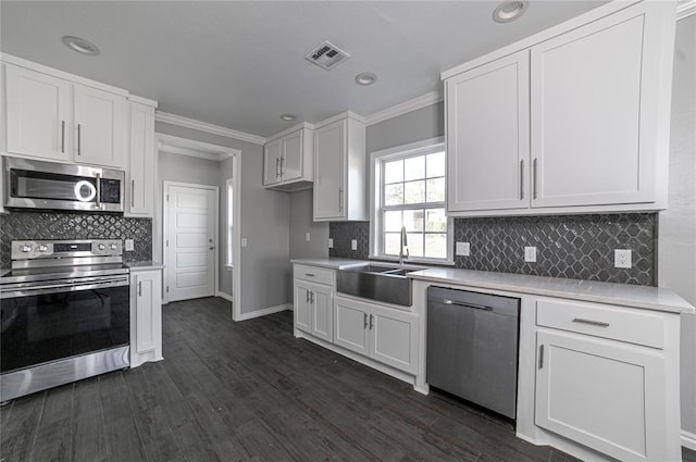 kitchen featuring white cabinetry, appliances with stainless steel finishes, crown molding, and sink