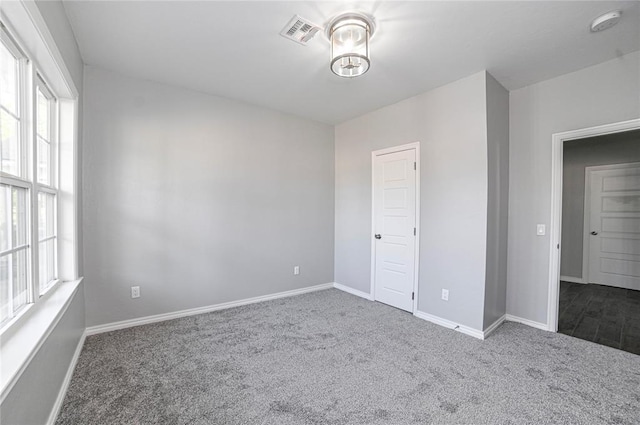 spare room with dark colored carpet