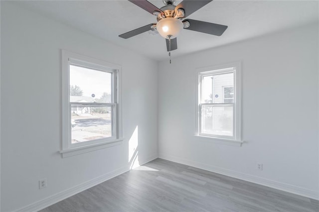 empty room featuring light hardwood / wood-style flooring, a wealth of natural light, and ceiling fan