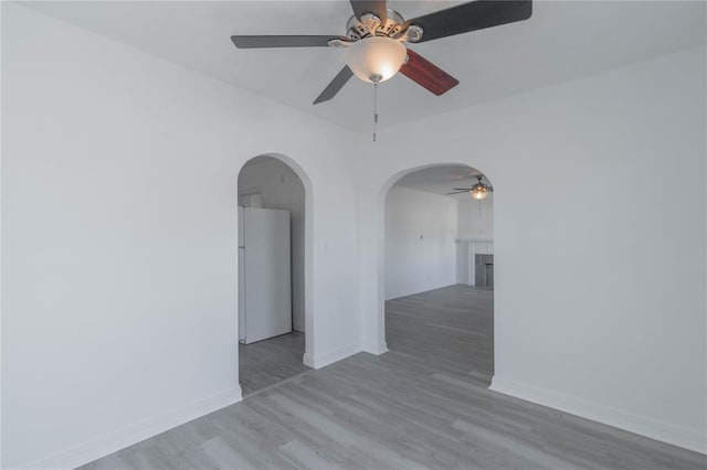 empty room featuring ceiling fan and light hardwood / wood-style flooring