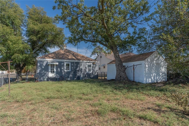 rear view of property with a storage shed and a lawn