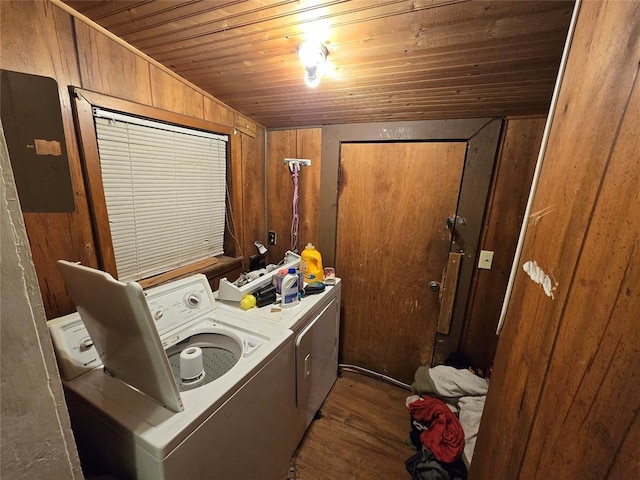 clothes washing area featuring hardwood / wood-style flooring, wooden walls, electric panel, separate washer and dryer, and wooden ceiling