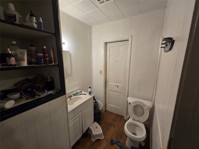 bathroom with hardwood / wood-style flooring, vanity, and toilet