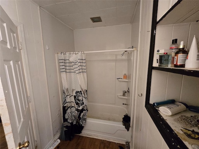 bathroom featuring hardwood / wood-style floors and shower / bathtub combination with curtain